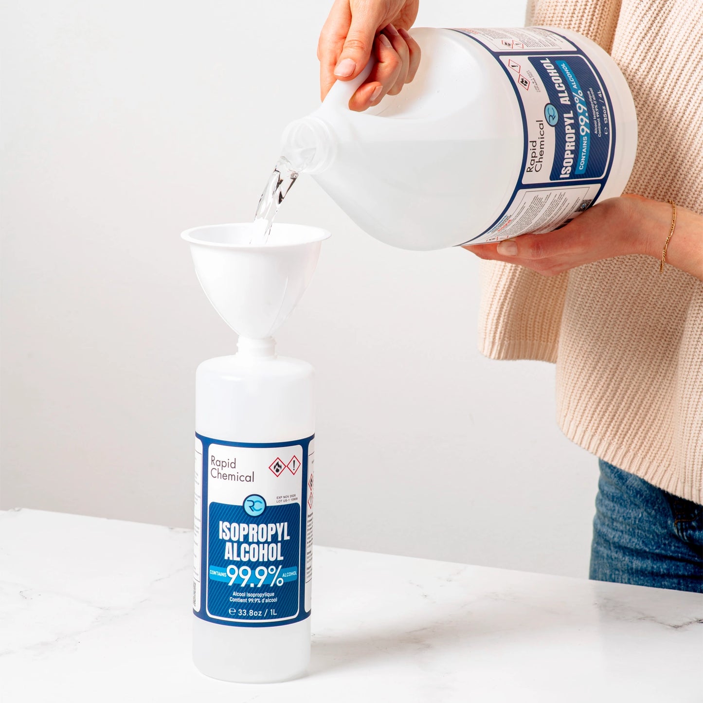 Pouring Rapid Protectant 99% isopropyl alcohol from 4L jug into 1L bottle.
